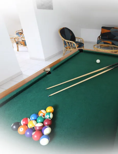 Billard américain avec queues et boules colorées dans la salle de jeux