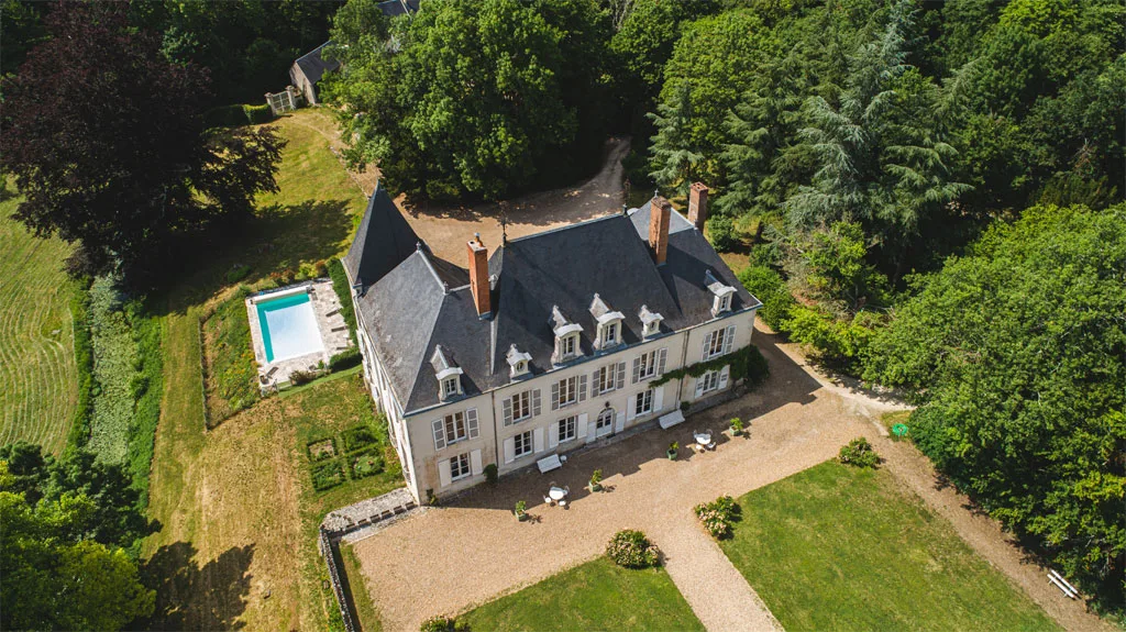 Gîte de groupe Château de Beaumont à Cour-Cheverny — Vue aérienne du Château de Beaumont avec ses toits en ardoise, la piscine et le parc arboré de 10 hectares, capacité 25 personnes