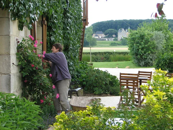 Vue exterieure du batiment principal en pierre avec toit en ardoise et jardin verdoyant
