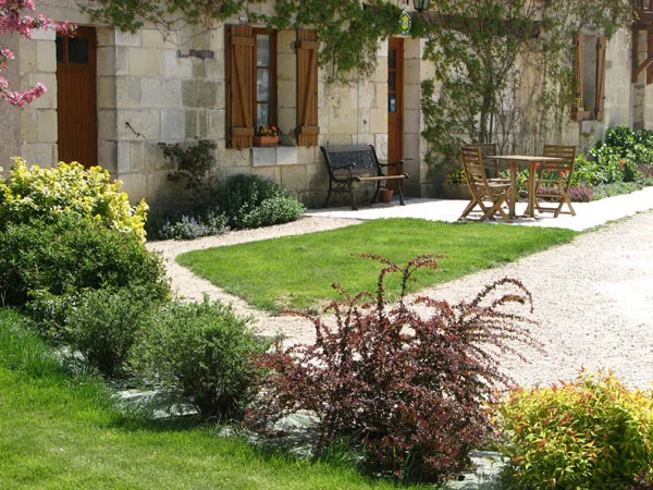 Terrasse couverte amenagee en coin repas avec table, chaises et salon de jardin