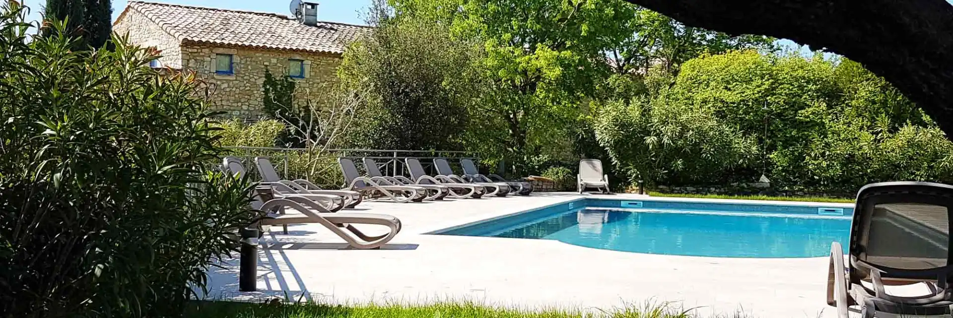 Piscine panoramique avec transats et vue dégagée sur la vallée et les collines provençales