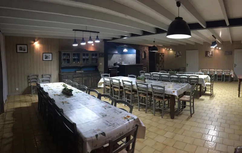 Salle à manger avec vaisselier ancien et coin cuisine carrelé bleu équipé d'une hotte