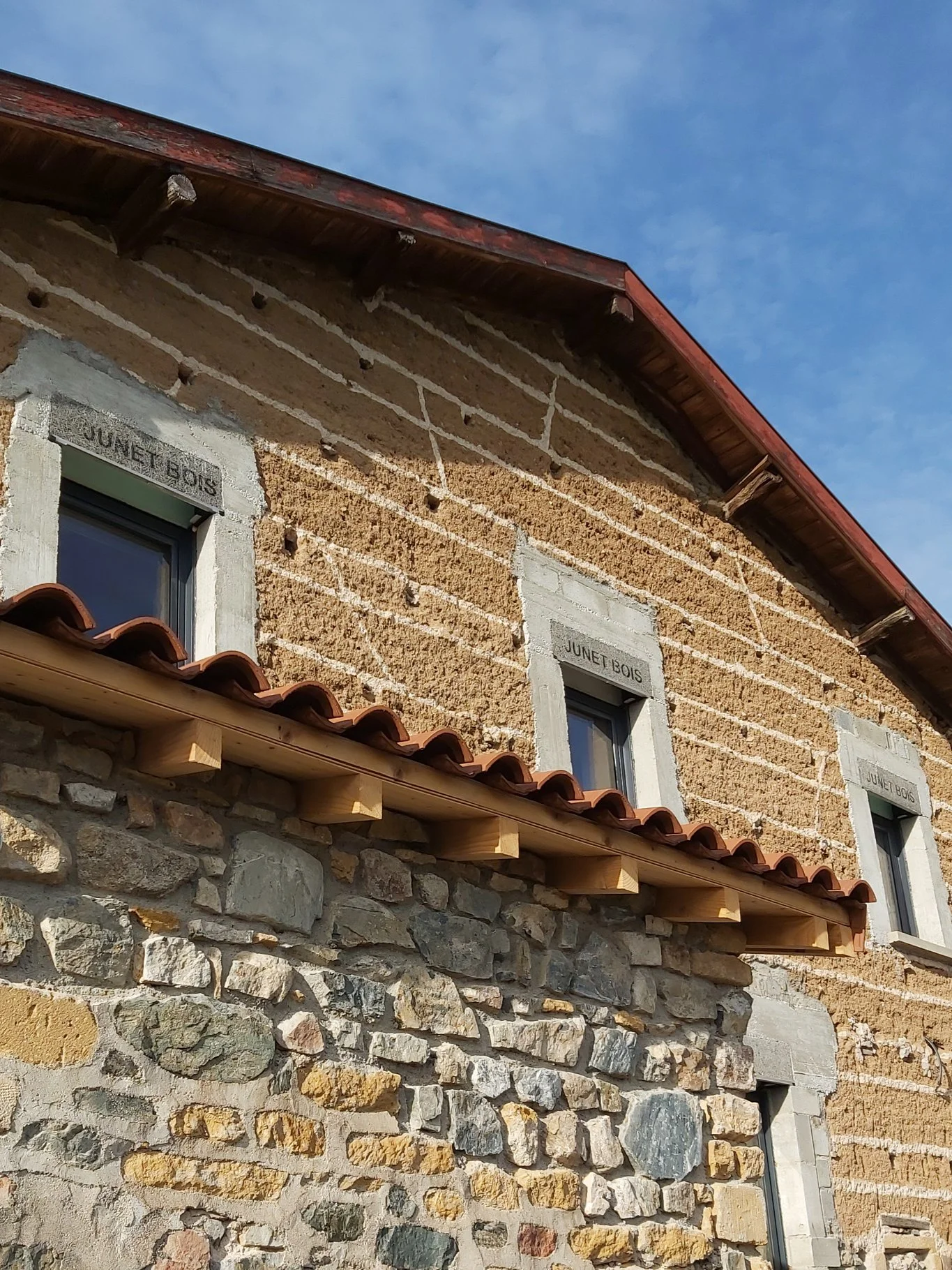 Gîte de groupe Domaine de Solémy à Bully — Façade en pierres dorées du Domaine de Solémy sous un ciel bleu avec vignoble en arrière-plan, capacité 15 personnes