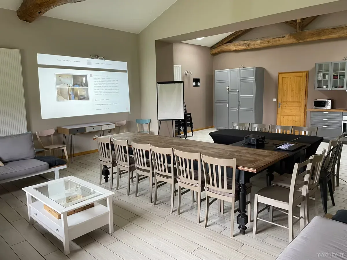 Grande salle de réception du Raph'iné avec poutres apparentes aménagée pour un séminaire