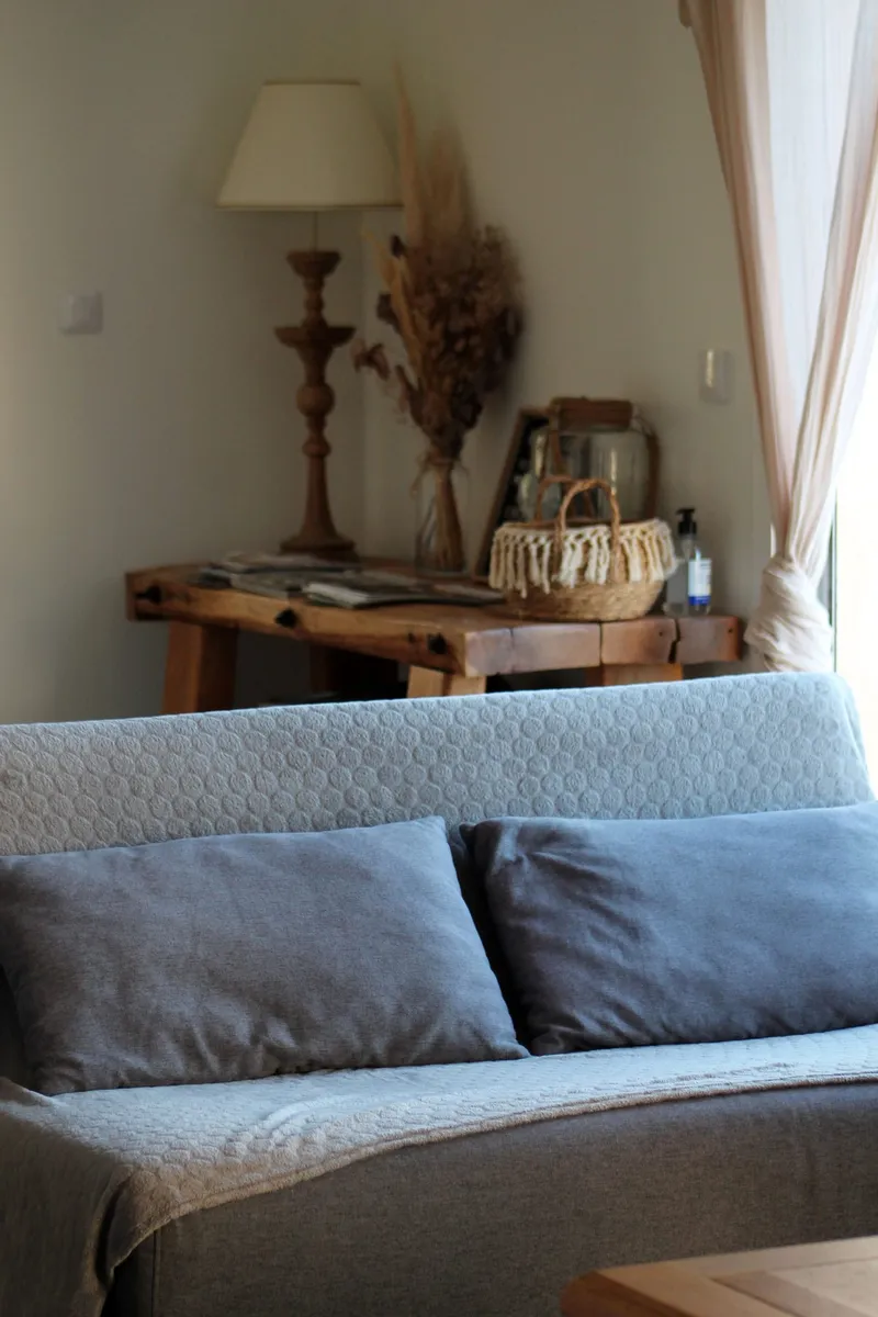 Coin salon avec canape confortable, lampadaire et decoration soignee aux tons naturels
