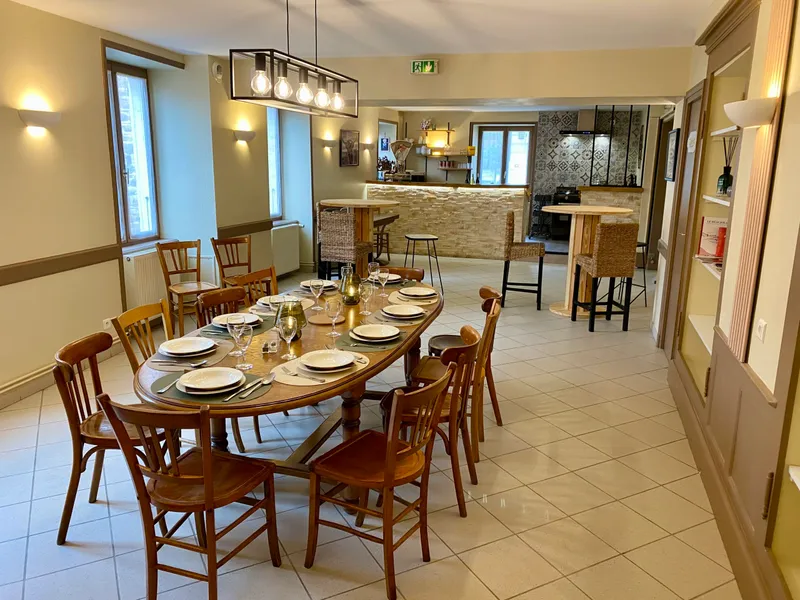 Salle à manger du gîte avec grande table commune et chaises