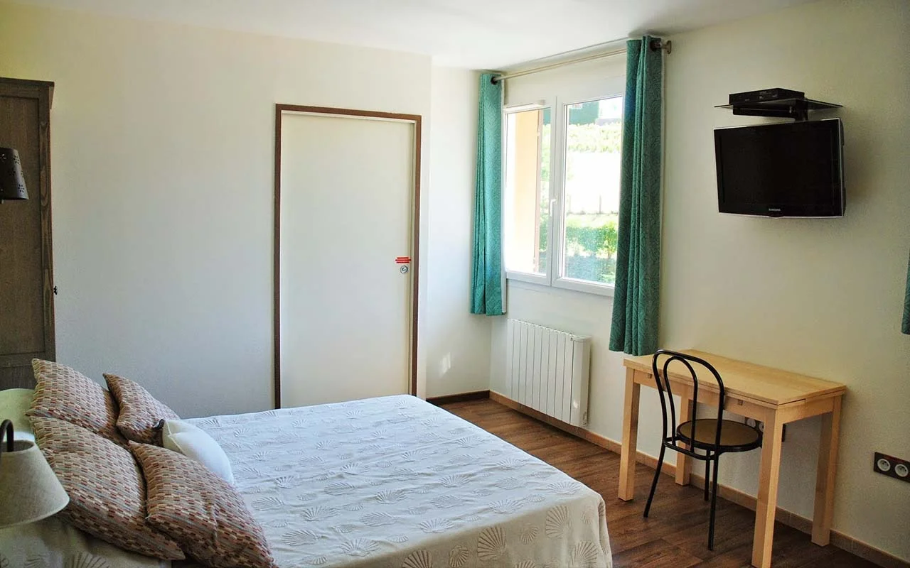 Chambre climatisée du gîte avec lit double et lits superposés pour quatre couchages