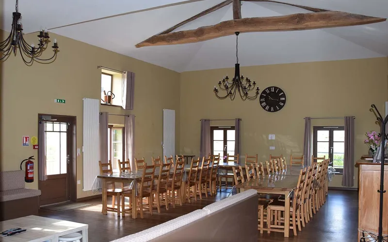 Grande salle à manger de 70 m² avec poutres apparentes du XIXe siècle et tables en U