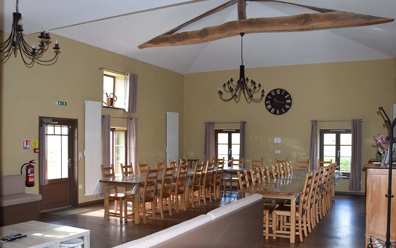 Grande salle à manger de 70 m² avec poutres apparentes du XIXe siècle et tables en U