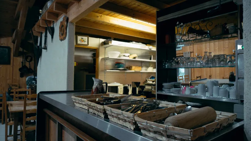 Coin cuisine avec comptoir bar et paniers en osier remplis de couverts, vaisselle rangée en arrière-plan