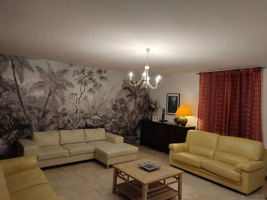 Séjour principal avec cheminée et décoration rustique en pierres et poutres apparentes