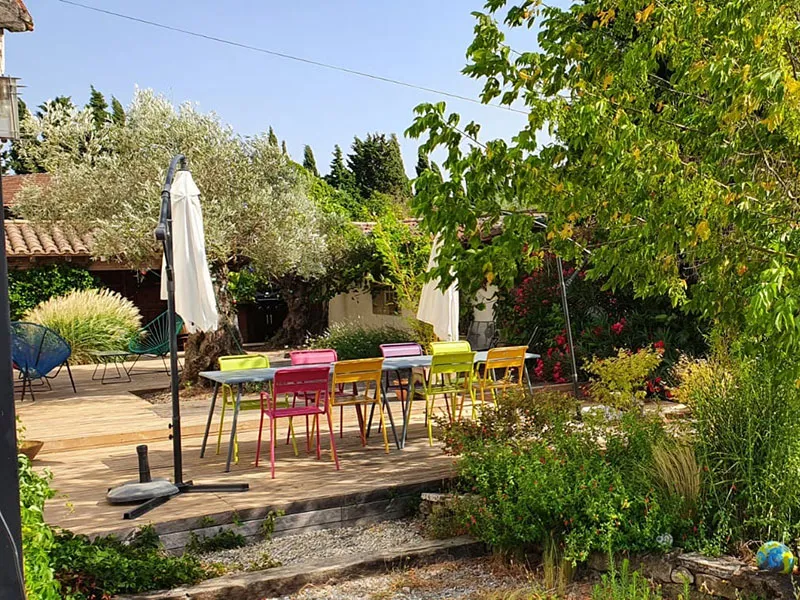 Coin repas extérieur sur terrasse ombragée avec table dressée