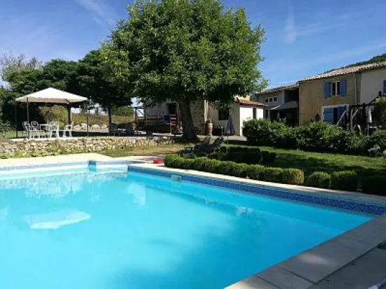 Piscine du domaine entouree de verdure avec transats
