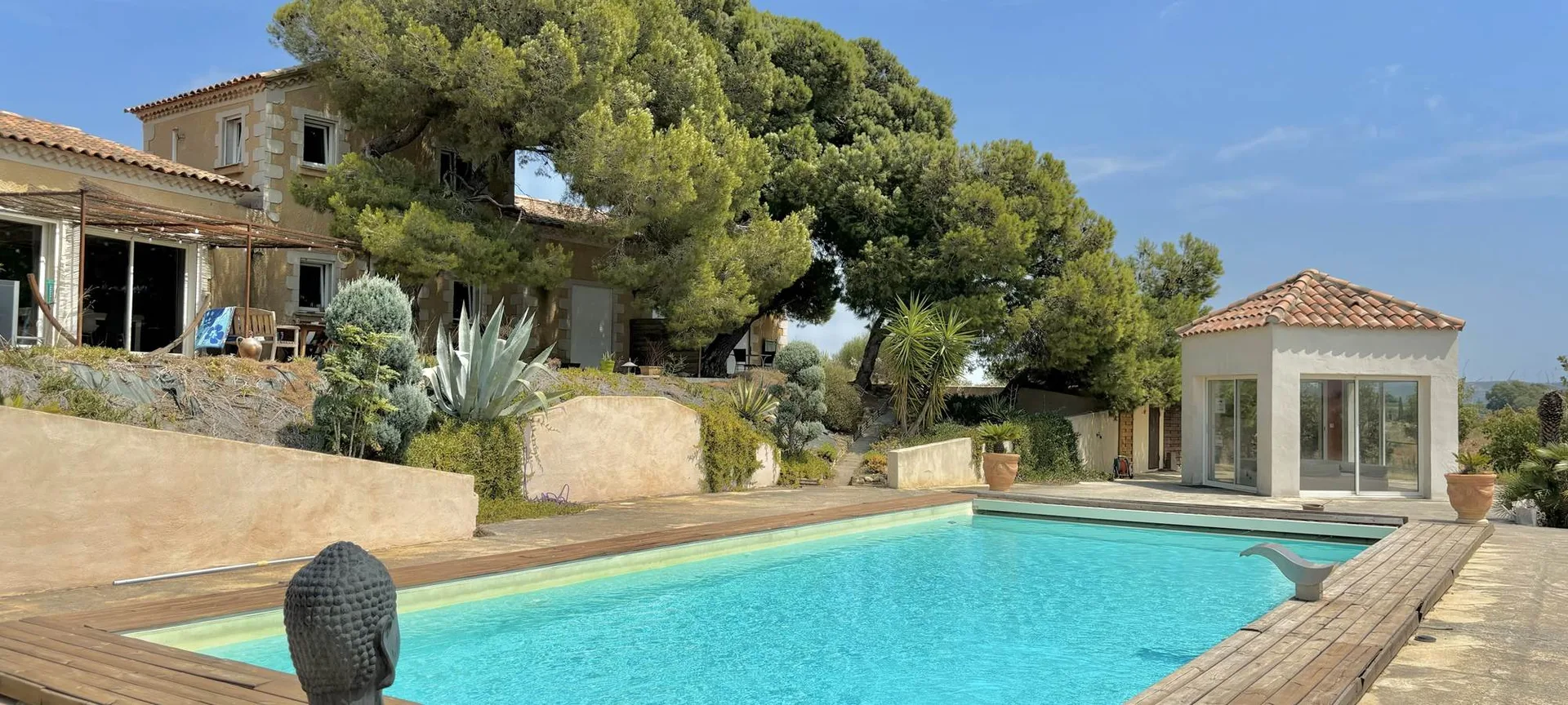 Gîte de groupe Domaine O Lingot d'Oc à Lezignan-Corbieres — Vue d'ensemble du domaine sous les pins avec piscine et spa, capacité 18 personnes