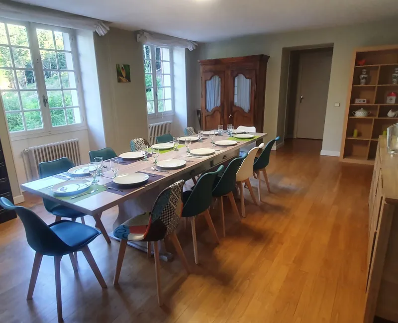 Salle à manger avec grande table dressée pour un repas de groupe