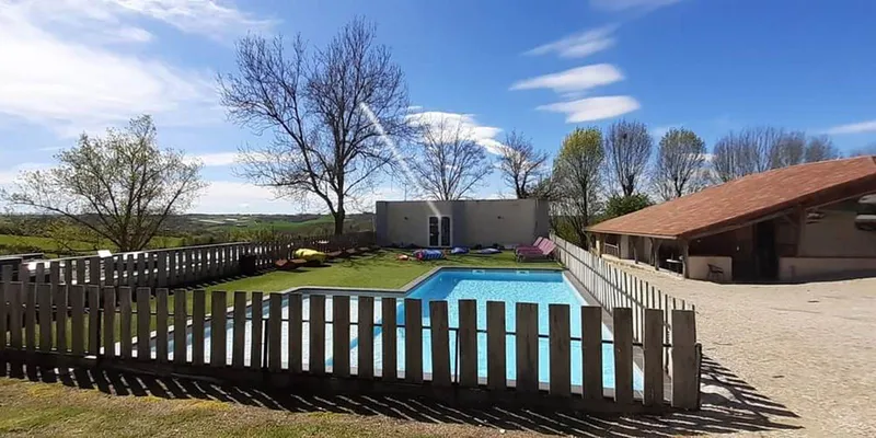 Piscine chauffée du domaine entourée de transats et de végétation