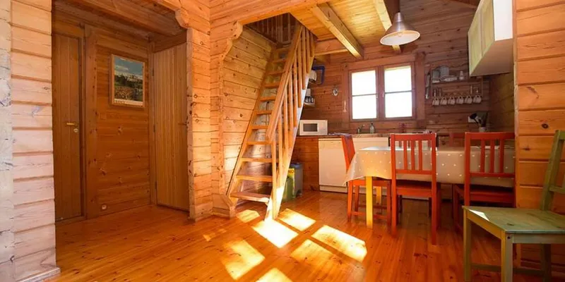 Intérieur chaleureux d'un chalet avec murs en bois massif et coin cuisine équipé