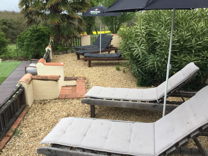 Terrasse couverte du domaine avec mobilier de jardin face aux collines gasconnes