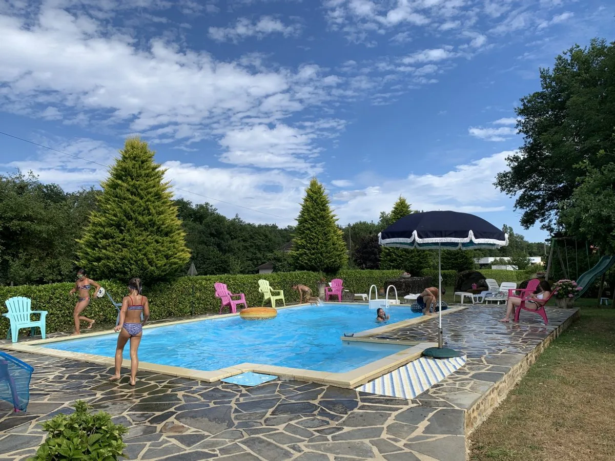 Gîte de groupe Les Gîtes du Quié à Aynac — Vue extérieure de la propriété des Gîtes du Quié avec terrasse et jardin arboré, capacité 22 personnes