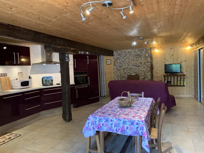 Espace de vie du gîte L'Étable avec cuisine ouverte et coin salon