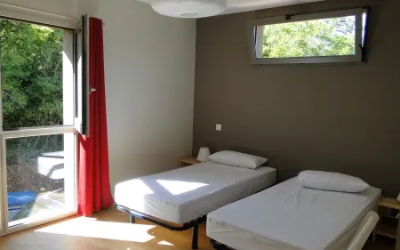 Chambre avec lits simples et literie soignée au Gîte de Galance