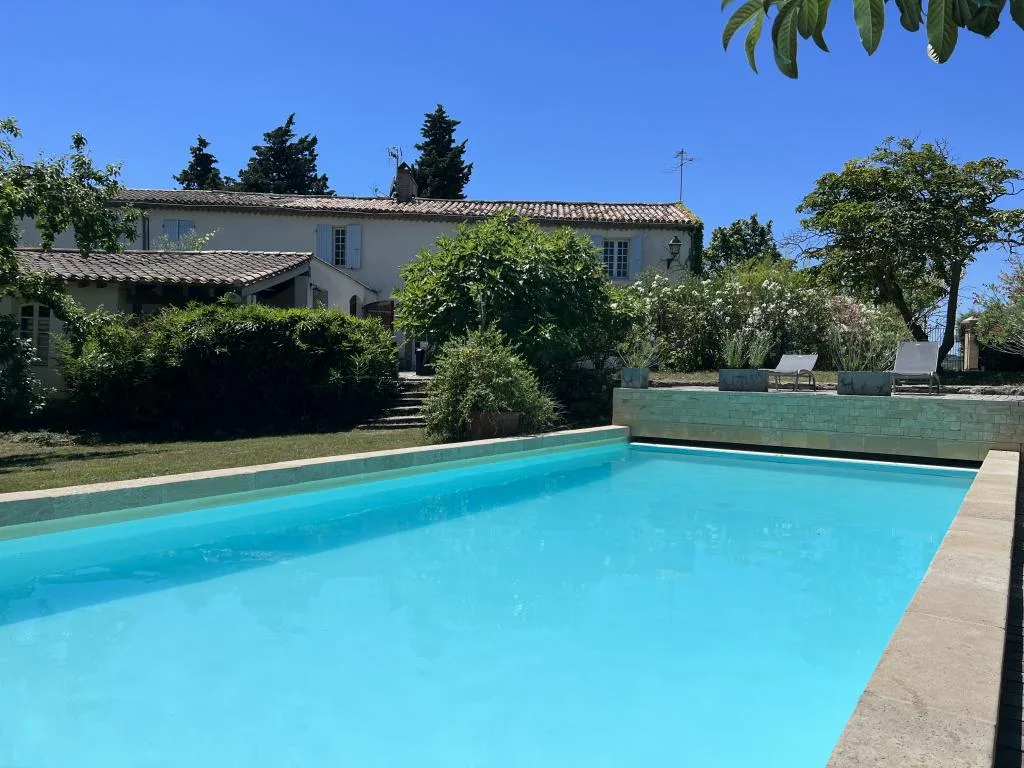 Gîte de groupe La Chouette Bleue à Labastide-d'Anjou — Facade en pierre des gites La Chouette Bleue vue depuis la piscine chauffee avec jardin arbore, capacité 24 personnes